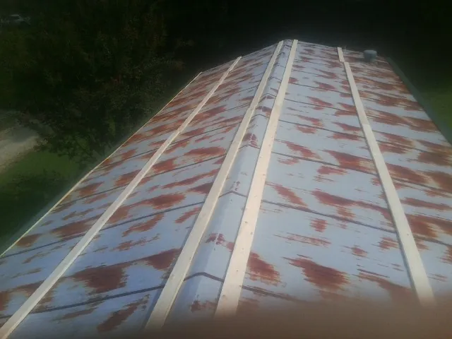 Rusted metal roof panels with new wood purlins before replacement — Storm Damage Roof Repair in South Holland by Roofing Brothers
