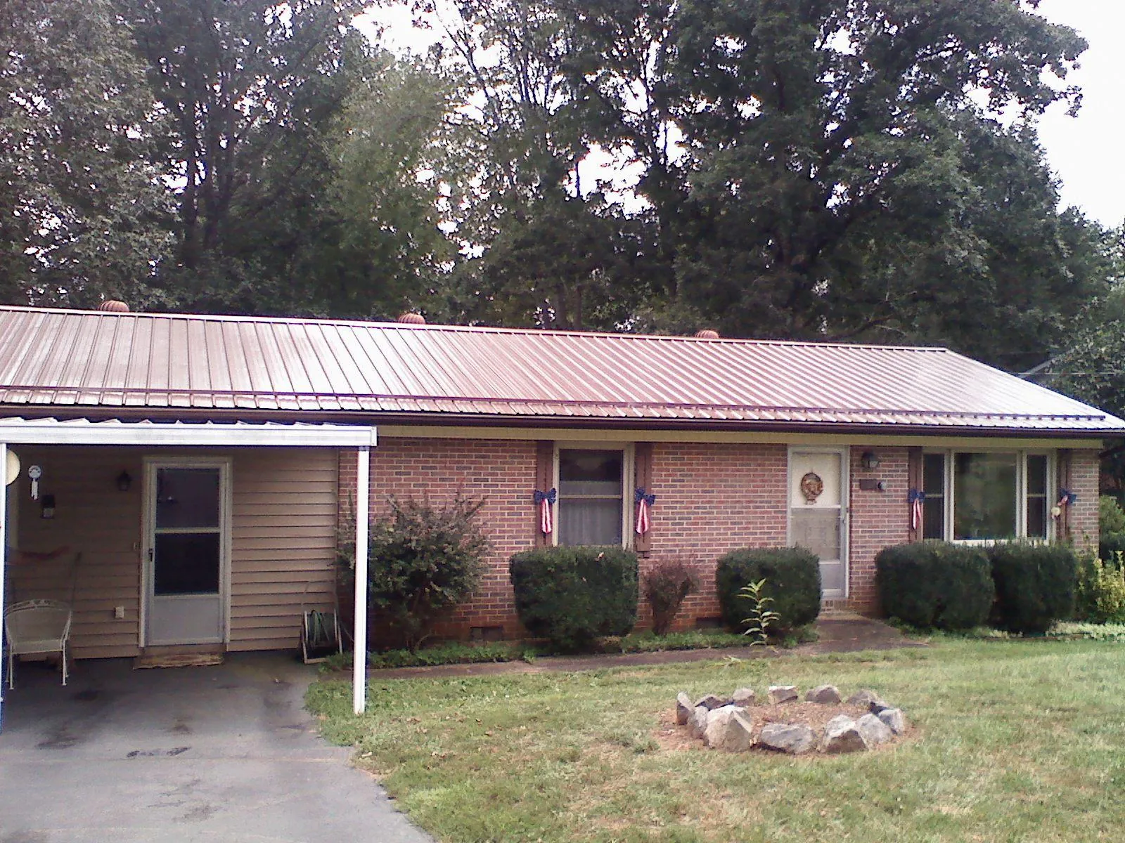 Bronze metal roof and carport on a brick ranch home — Roof Repair work by our crew in South Holland